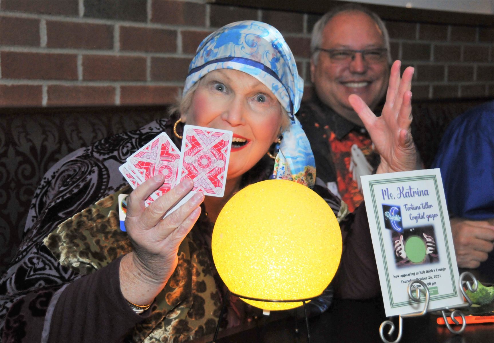 Ms. Katrina (Karen DeAngelis) tells fortunes as Glenn Harbin looks on
